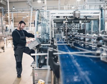 Happy smiled worker doing his job on Robotic factory line for pr