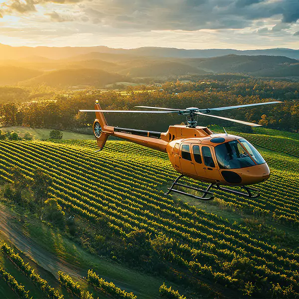 Turbine helicopter flying over winery in Australia financed with helicopter loan made possible by QPF Aviation Finance Broker